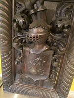 Close view of helmet-shaped crest and shield with lion motif