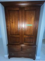 Full front view of closed dresser showing two doors above four drawers