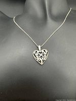 Front view of the silver filigree heart pendant on a chain, showing overall design and necklace length.