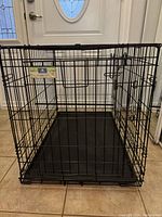 Full view of the black metal wire folding crate with plastic base tray, showing structure and size.