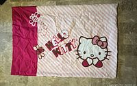Front side of the vintage Hello Kitty pillow case displayed flat on a tiled floor, showing the full character design and branding.