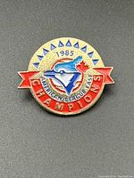 Front view of the round 1985 Toronto Blue Jays American League East Champions pinback showing the team logo, championship text, and decorative details in gold, red, and blue tones.
