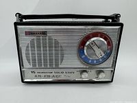 Front view of the Granada portable radio showing the speaker grille, tuning dial with AM/FM indicators, and control knobs.