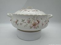 Photo of a round porcelain covered vegetable serving bowl with floral decoration, gold trim, and lid knob.
