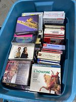 Photo of blue bin filled with music CDs and DVDs showing musical and classical music items on top including Verdi's Il Trovatore.