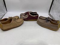 Three pairs of Clarks Originals shoes arranged side by side showing different colors and styles.