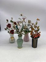 Four metal floral bouquets placed side by side showing vases and flower arrangements