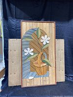 Front view of the signed and numbered wood art panel featuring a basket with flowers design.