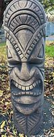 Front close-up photo of tiki statue showing detailed facial carvings and texture.