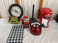 Wide view showing all items in the kitchen collection including Keurig coffee maker, kettle, salt and pepper shakers, basket, Coca-Cola tin, and wall clock.