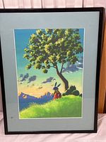 Full view of framed lithograph showing rabbit sitting under a tree on a grassy hill with mountain sunset background.