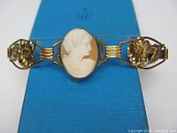 Front view of the antique gold filled cameo bracelet showing the hand carved shell profile cameo and floral side links.