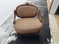 Front view of antique wooden framed settee with striped upholstery showing overall shape and condition.