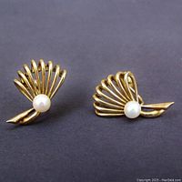 Front view of the pair showing shell-like gold design and pearl placement