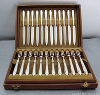 Open original box showing 12 silver knives in lid and 12 forks in base