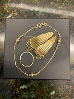 Bracelet, earrings and ring arranged on black box