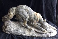 Front-left view of the marble wolf sculpture on rough base.