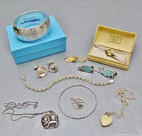 Overview of all jewelry pieces and Birks boxes on gray background