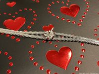 Close-up image focusing on the filigree flower centerpiece decorated with red stones and the herringbone band texture