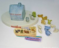 Wide view of the Red Rose Tea pet shop display stand with multiple small Wade Noah's Ark series figurines around it, plus collector's cards detailing the series.
