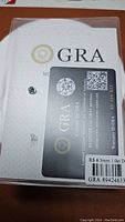 Certified loose moissanite gemstone in protective box with GRA certification card and warranty.
