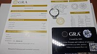 Certificate and ring front view showing grading and authentication details, including the ring's adjustable band hook.