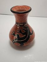 Front angled view displaying the black lizard design on reddish-brown textured pottery vase with flared lip.