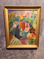 Full front view of signed abstract oil painting in gold frame showing geometric shapes, guitar, sheet music