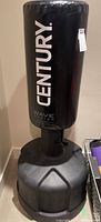 Full view of the upright freestanding Century Wave Master boxing bag with black padded striking surface and wide base.
