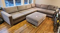 Overall view of the L-shaped sectional sofa with ottoman in room