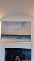 Full view of large canvas wall art showing the entire seascape composition on a white fireplace mantel.