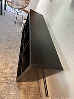 Side view of one long 4x2 black IKEA Kallax shelving unit showing overall structure.