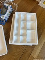 Photo showing white plastic drawer organizers with sections for sorting items.