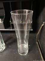 Tall pilsner glass with narrow base broadening to rim, clear glass