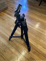 Front view of black Velbon tripod with legs extended and top mounting plate visible