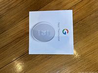 Top view of the Nest Thermostat box with Google logo and product image.