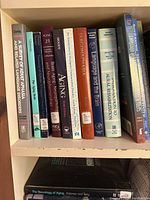 Books on a shelf covering aphasia, aging, brain studies, language, and medical rehabilitation topics.