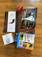 Overview of all items including the boxed Wonder Woman doll, laptop case, speakers, thermostat, and talking buttons.