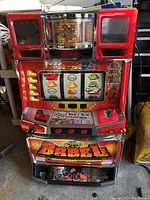 Front view of red Babel-themed pachislo slot machine showing reels, buttons, lever, coin tray