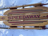Close-up top view of the wooden Speedaway sled showing detailed painted design and name.