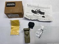 Brand new Feyachi reflex sight with box, instruction sheet, cleaning cloth, rubber lens cover, and mounting hex wrench. Olive green sight body with adjustment knob visible.