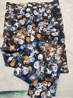 Floral pants showing full length with a vibrant colorful floral print on dark fabric.