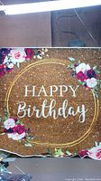 Front view of the large rectangular 'Happy Birthday' party sign showing the full floral and gold glitter design.