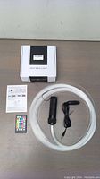 Complete LED fiber optic light kit with fiber strands, LED light source, power cord, remote control, instruction manual, and packaging box.
