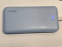 Top view of blue Miady portable power bank showing the brand logo and LED battery indicator lights on surface.