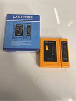 Photo of blue box and two-part orange cable tester device