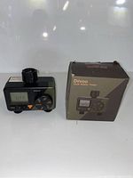 Photo of Diivoo dual water timer next to its original packaging box showing front and connector top view.