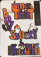 Top view of four Halloween wooden decorations laid out showing designs and accompanying stands