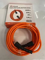 Uxixed high pressure washer hose coiled with box showing key specifications (3600 PSI, 250 BAR, 25 ft length, 1/4 inch diameter)