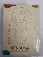 Front of packaging box showing illustration and basic features of the Kensuka Baby Stroller Fan BF1 shaped like a rounded character with fan blades in center.